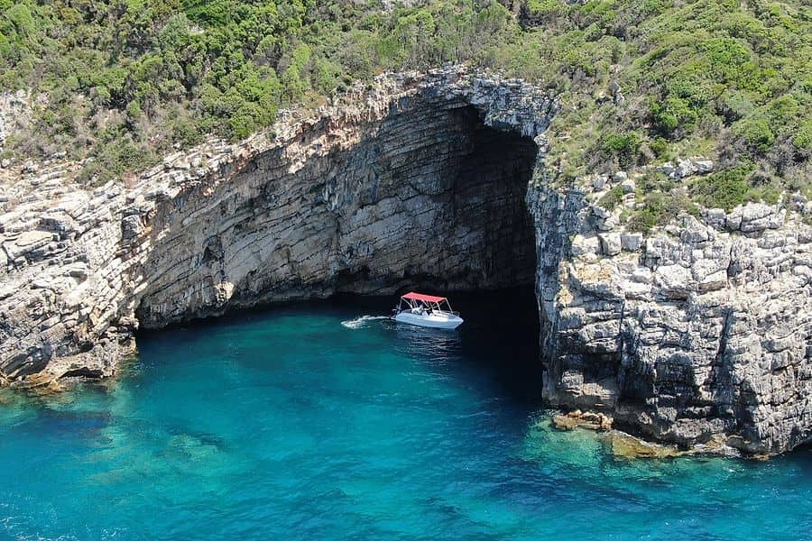 A Corfu boat trip boat at the entrance of a sea cave near Paleokastritsa