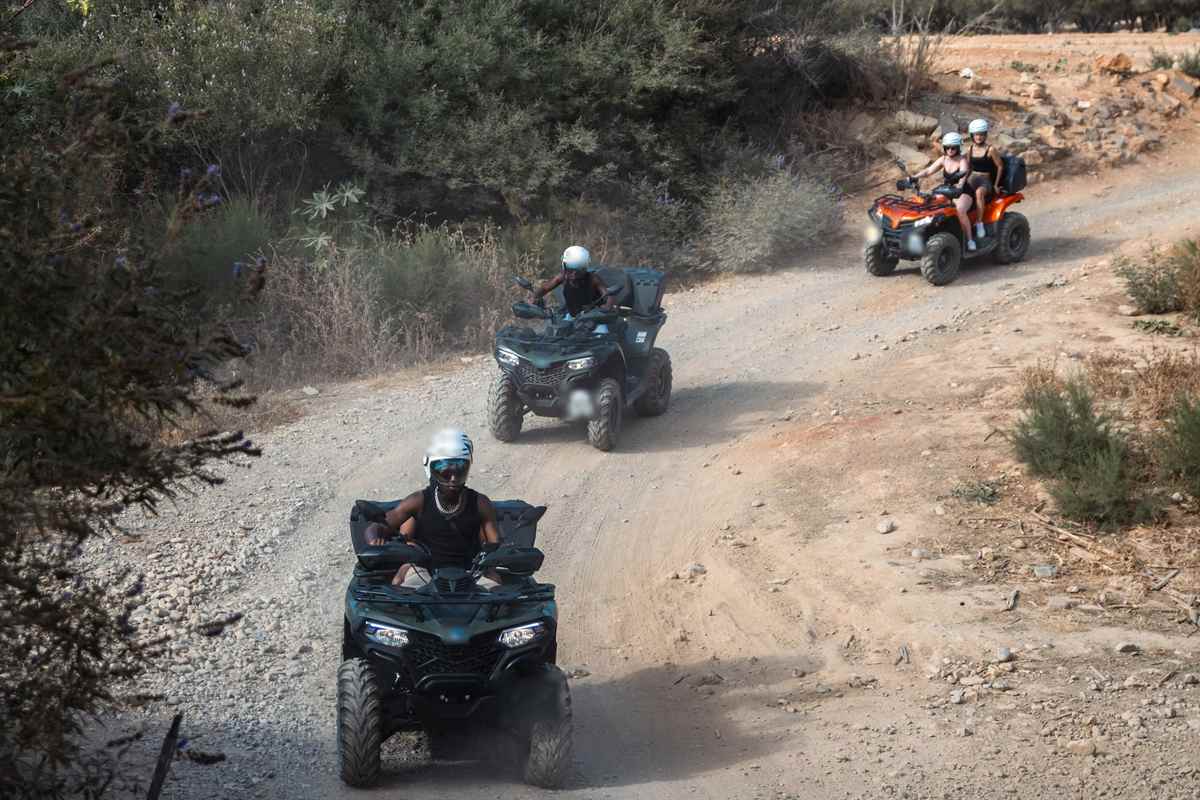 Crete quad tour riders in helmets on ATVs riding a dirt track through Cretan countryside
