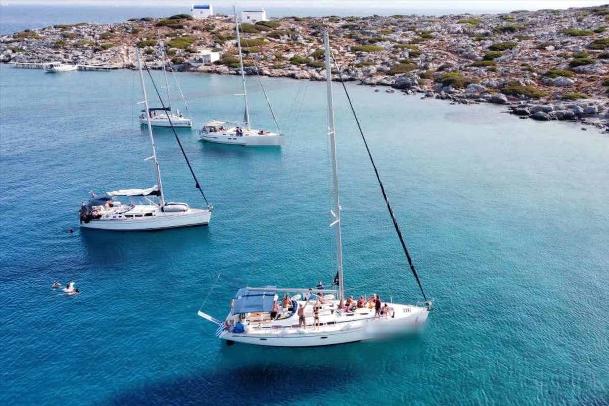 Sailing yachts anchored in a turquoise bay of Dia during a Dia island cruise from Heraklion