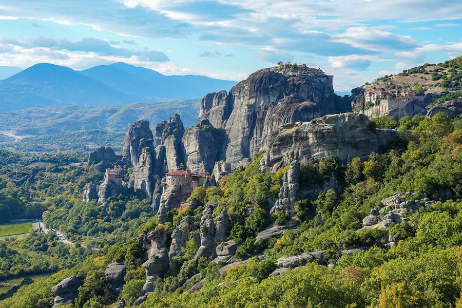 The Meteora monasteries on their sandstone rock pillars above green woods, a classic stop on Greece tours