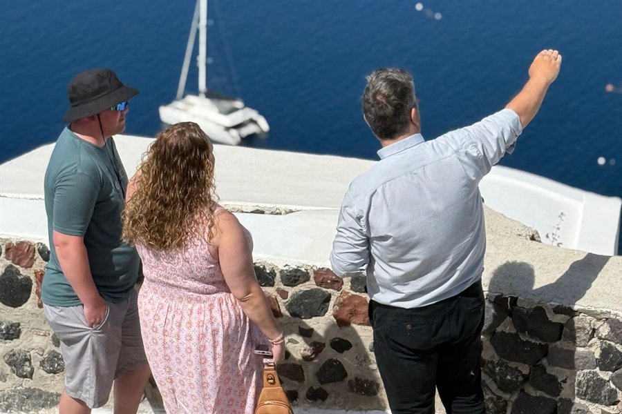 Local host points out the caldera to two guests on a Santorini private tour