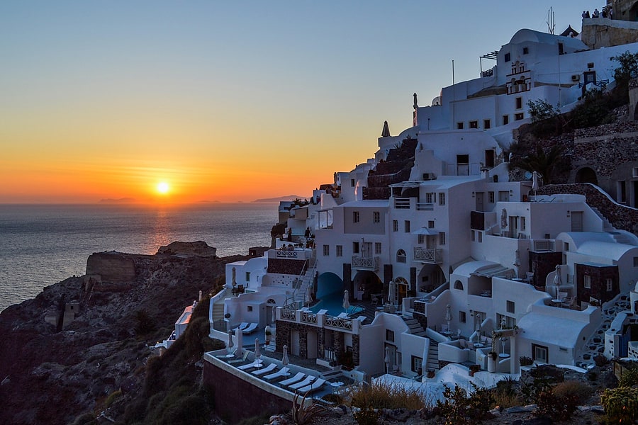 Oia's white cave houses above the sea at sundown, the classic finale of a Santorini sunset tour