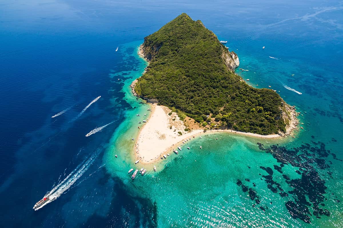 Zakynthos turtle boat tour: aerial view of tour boats heading to Marathonisi (Turtle Island) across the turquoise water of Laganas Bay